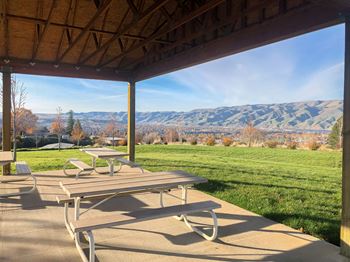 a patio with picnic tables and a view of the mountains  at Canyon View, Idaho, 83501